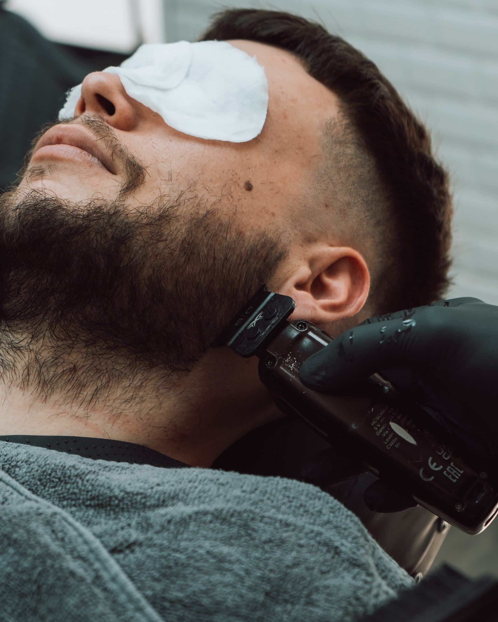 Perfilado de barba con máquina y degradado limpio sobre la oreja